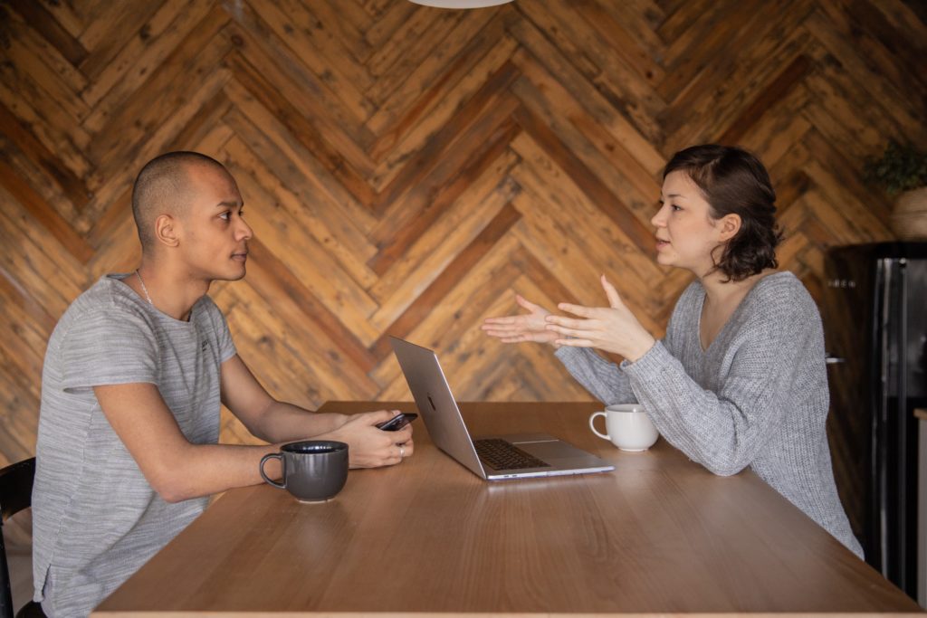 man and women talking at table